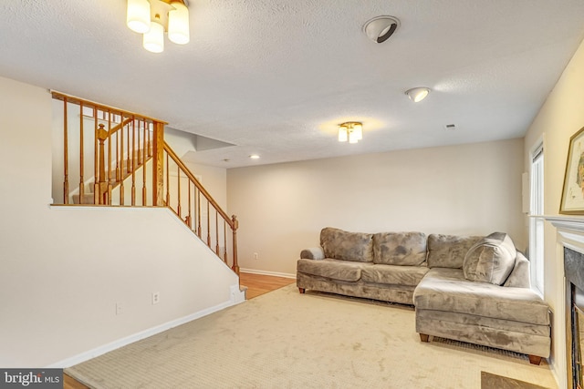 living room with hardwood / wood-style floors, a fireplace, and a textured ceiling