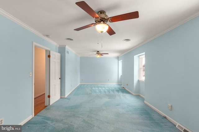 carpeted spare room featuring ceiling fan and ornamental molding