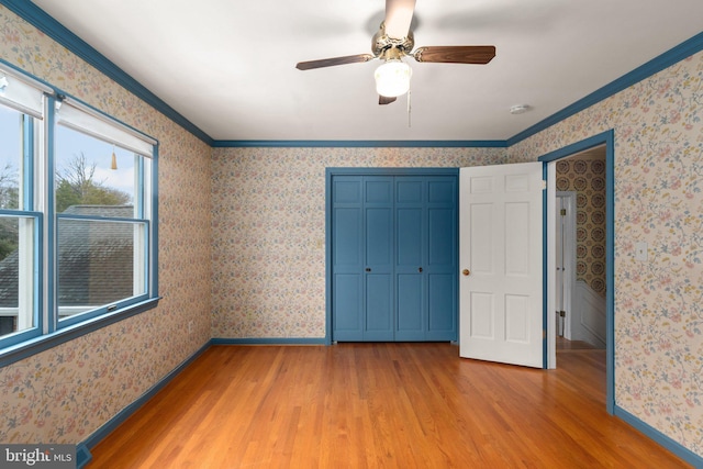 unfurnished bedroom with ceiling fan, crown molding, and light hardwood / wood-style floors