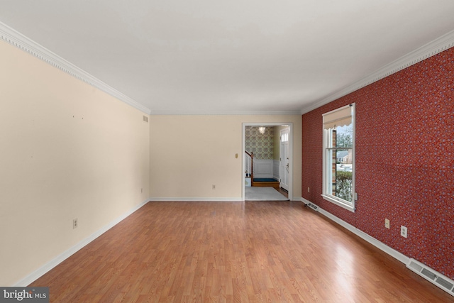 empty room featuring light hardwood / wood-style flooring and crown molding