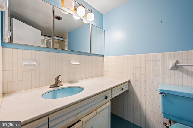 bathroom featuring walk in shower, vanity, and tile walls