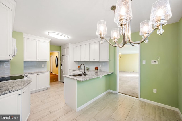 kitchen with fridge with ice dispenser, backsplash, decorative light fixtures, and white cabinets