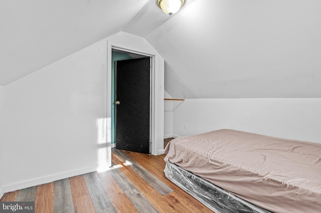 bedroom with lofted ceiling and light wood-type flooring