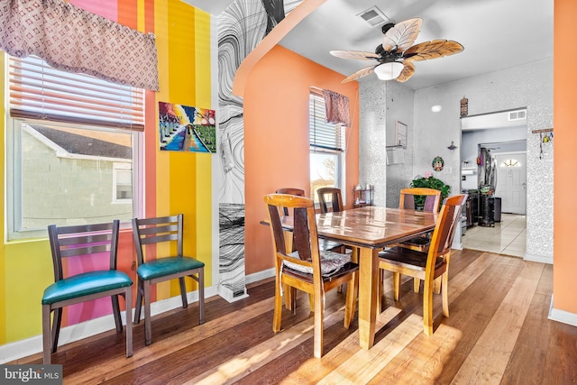 dining space with ceiling fan and hardwood / wood-style flooring