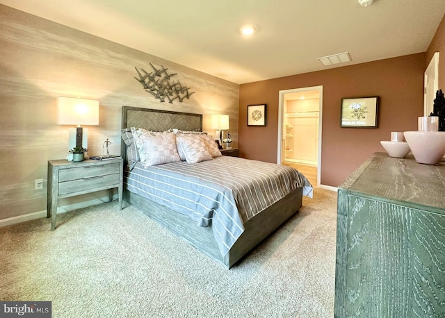 bedroom featuring ensuite bathroom and carpet floors