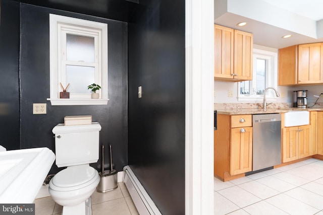 kitchen featuring baseboard heating, light tile patterned flooring, dishwasher, and light brown cabinets