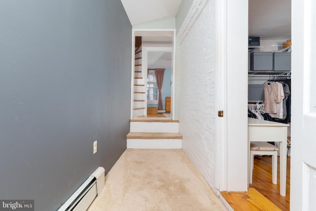 hallway with carpet floors, vaulted ceiling, and baseboard heating