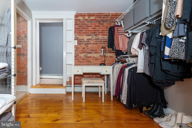 spacious closet featuring hardwood / wood-style floors and a baseboard radiator