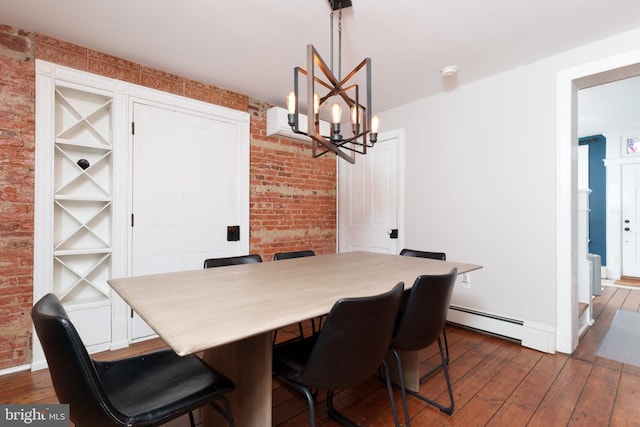 dining room with a notable chandelier, a baseboard radiator, brick wall, dark hardwood / wood-style flooring, and built in shelves