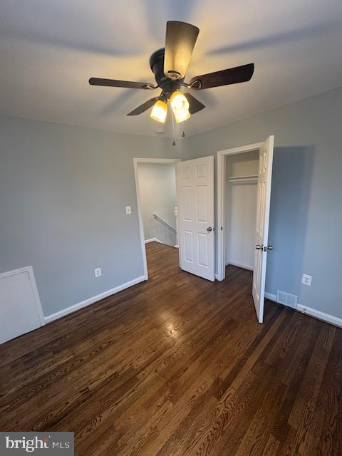 unfurnished bedroom featuring ceiling fan, a closet, and dark hardwood / wood-style floors