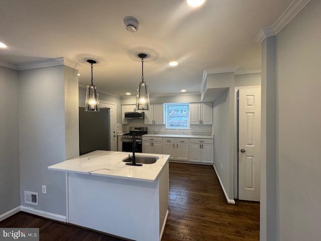 kitchen featuring white cabinetry, kitchen peninsula, backsplash, fridge, and sink