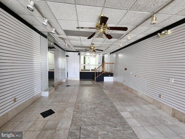 interior space featuring wood walls and ceiling fan