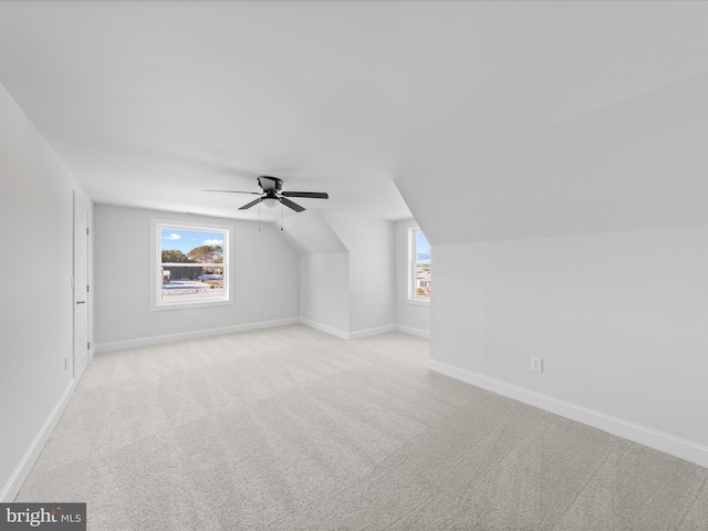 bonus room with ceiling fan, lofted ceiling, a healthy amount of sunlight, and light colored carpet