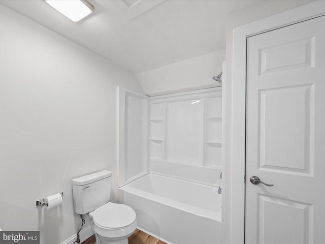 bathroom featuring wood-type flooring, washtub / shower combination, and toilet