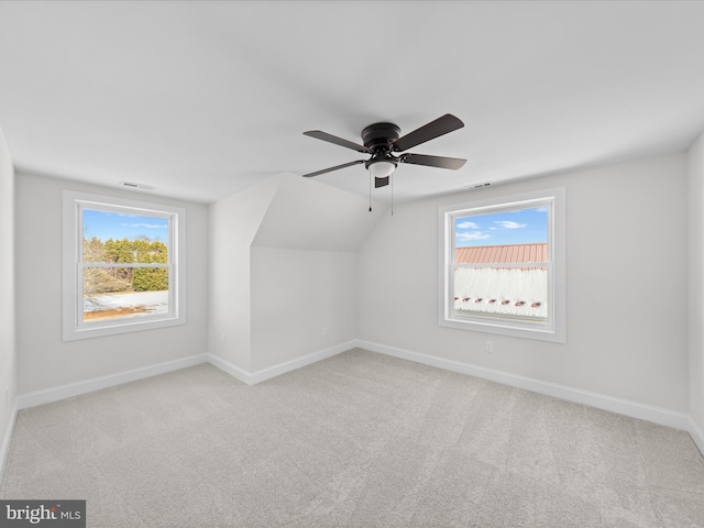 bonus room with plenty of natural light, light colored carpet, lofted ceiling, and ceiling fan