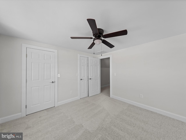 unfurnished bedroom with light colored carpet and ceiling fan