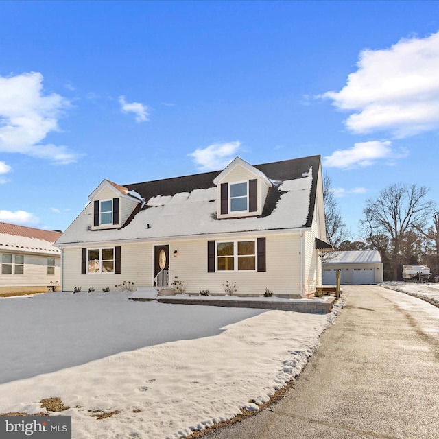 cape cod home with a garage and an outdoor structure