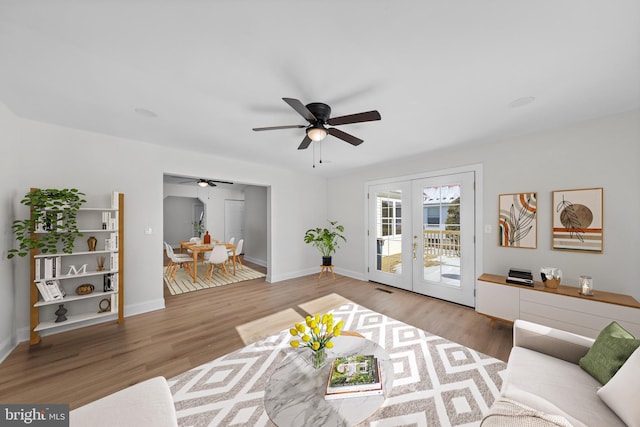 living room featuring french doors, ceiling fan, and wood-type flooring