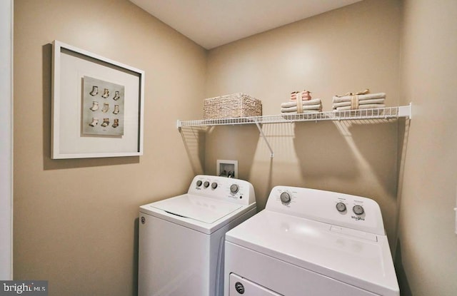 clothes washing area with washer and clothes dryer