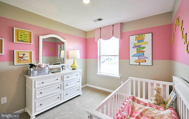 bedroom featuring a crib and light colored carpet