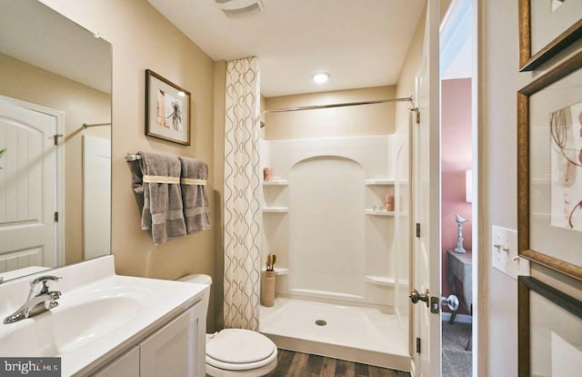 bathroom featuring toilet, a shower with shower curtain, vanity, and hardwood / wood-style floors