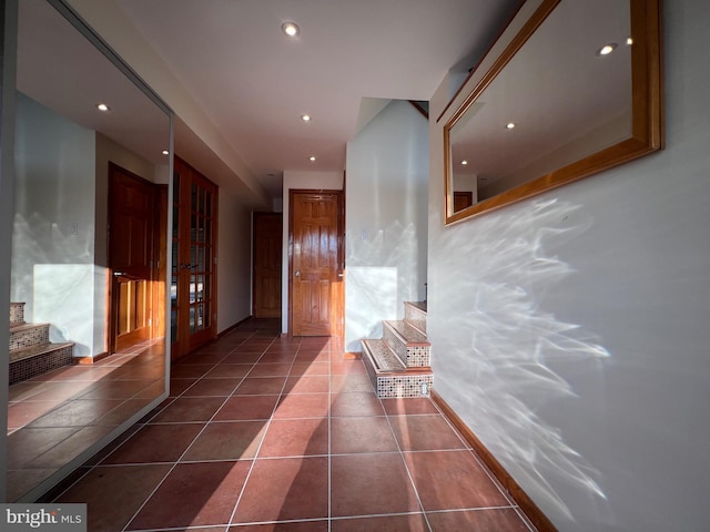 hall featuring french doors and dark tile patterned floors