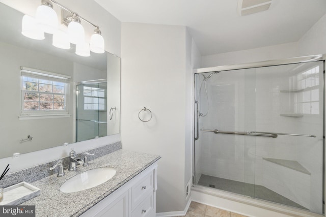 bathroom featuring a shower with door, vanity, and tile patterned floors