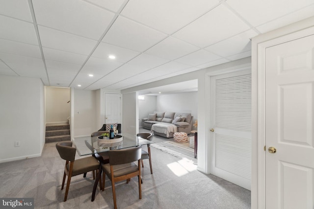 carpeted dining room with a drop ceiling