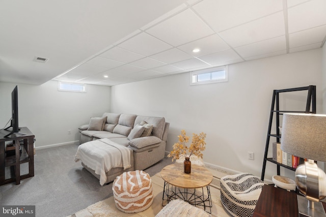 carpeted living room featuring a drop ceiling and a wealth of natural light