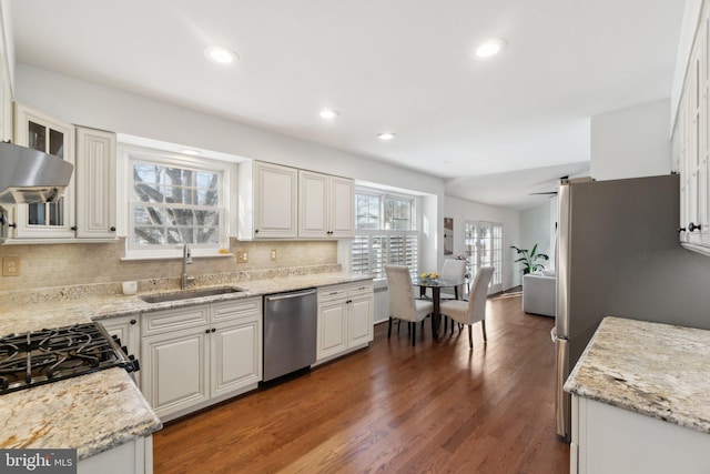 kitchen featuring sink, stainless steel appliances, white cabinetry, and light stone counters