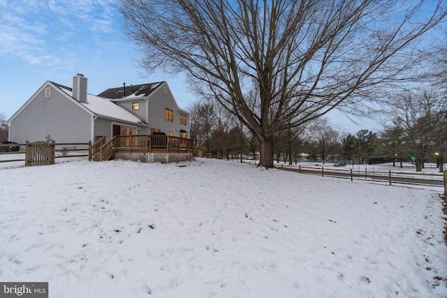 yard covered in snow featuring a wooden deck