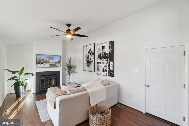 living room with dark wood-type flooring and ceiling fan