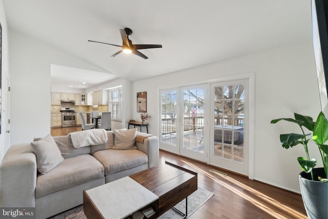 living room featuring lofted ceiling, ceiling fan, and dark hardwood / wood-style floors