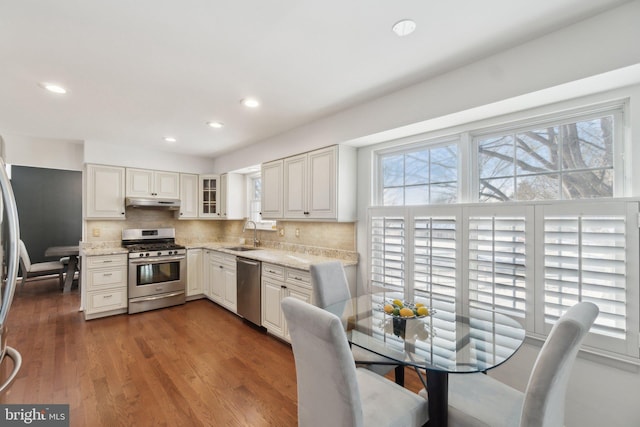 kitchen featuring appliances with stainless steel finishes, tasteful backsplash, white cabinets, and sink