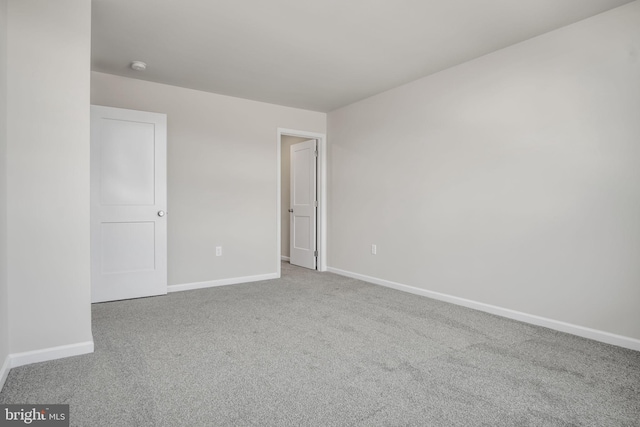 spare room featuring carpet flooring and baseboards