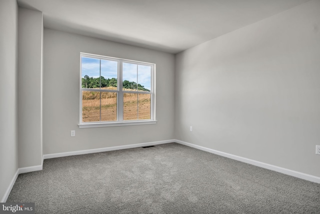 unfurnished room featuring carpet flooring, visible vents, and baseboards