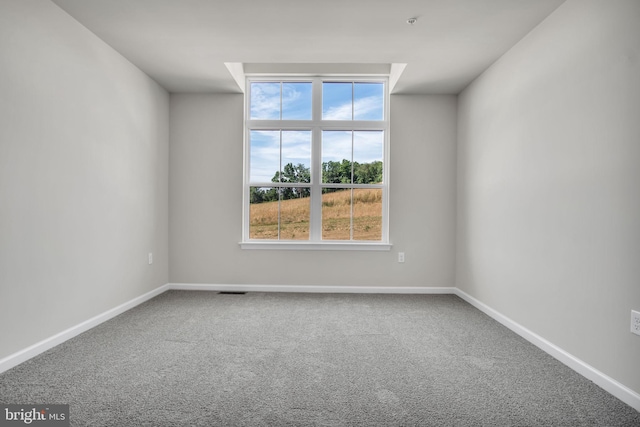 unfurnished room featuring carpet and baseboards