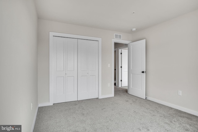 unfurnished bedroom with a closet, visible vents, baseboards, and carpet flooring