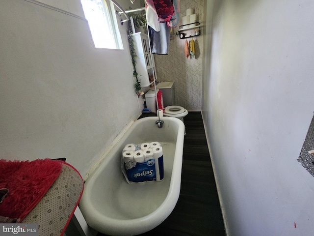 bathroom with toilet, water heater, and a tub