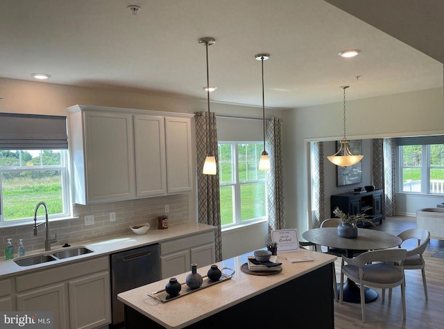 kitchen featuring sink, hanging light fixtures, white cabinets, and dishwasher