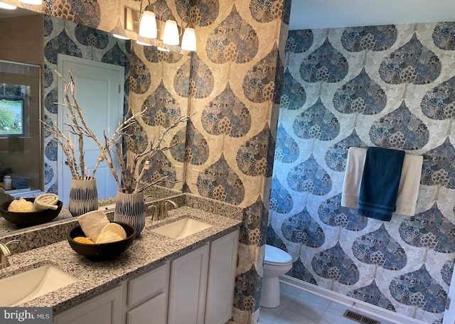 bathroom with toilet, tile patterned flooring, a shower with shower door, and vanity