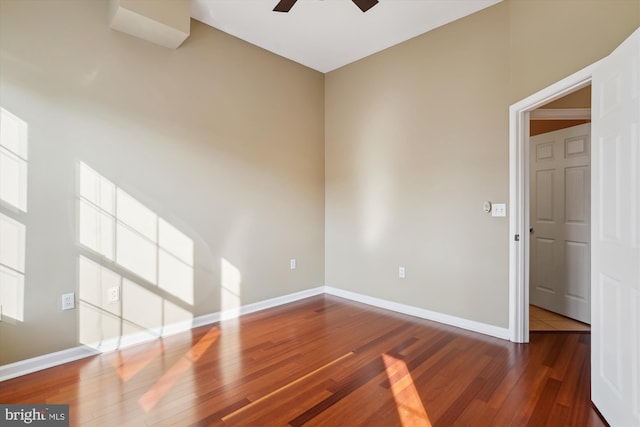 unfurnished room with ceiling fan and dark hardwood / wood-style flooring