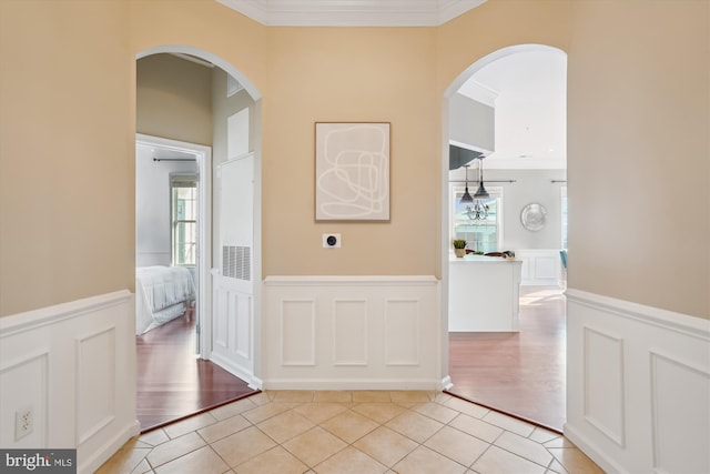 corridor featuring light tile patterned flooring and ornamental molding