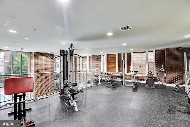 exercise room featuring brick wall