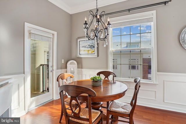 dining room featuring hardwood / wood-style flooring, crown molding, and a notable chandelier