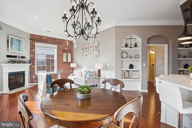 dining area with built in shelves, brick wall, crown molding, and dark wood-type flooring