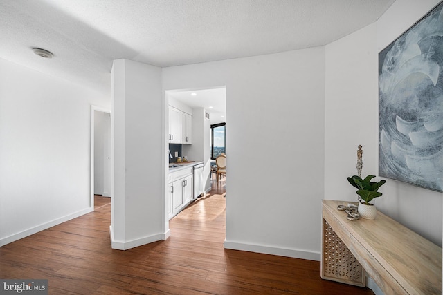 corridor featuring a textured ceiling and wood-type flooring