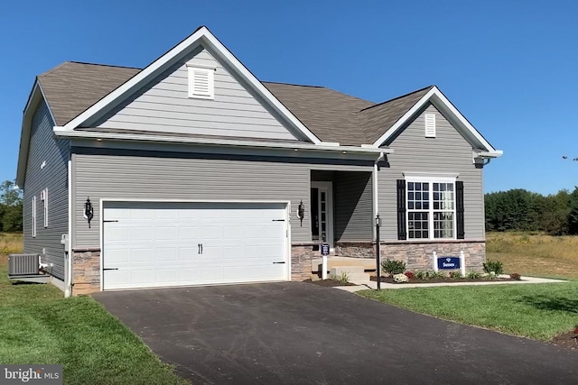 view of front of property with central AC unit, a garage, and a front lawn