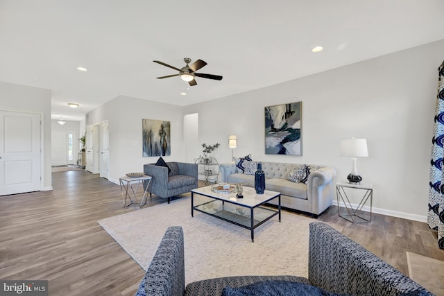 living room with wood-type flooring and ceiling fan