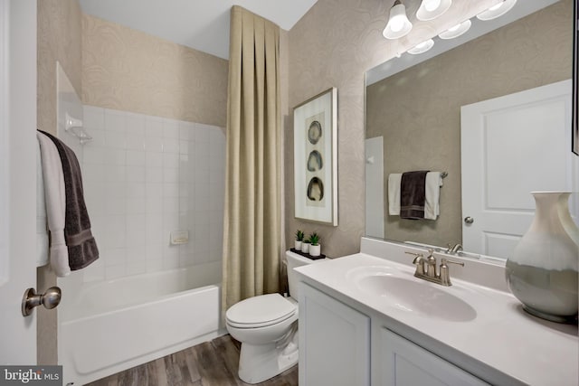 full bathroom featuring toilet, vanity, hardwood / wood-style flooring, and shower / tub combo with curtain